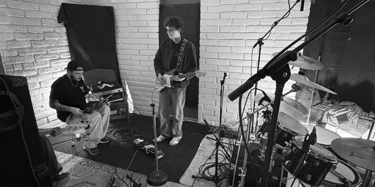 Bass, drums, guitars tracking together with DAW laptop, cables, and amps in background